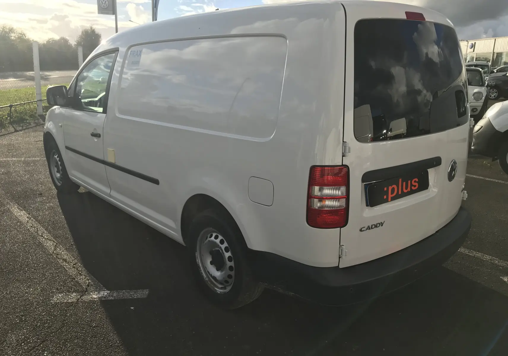 Vue 3/4 arrière droite d'un utilitaire Volkswagen Caddy Maxi Van frigo blanc avec vitres arrière teintées et feux rouges.
