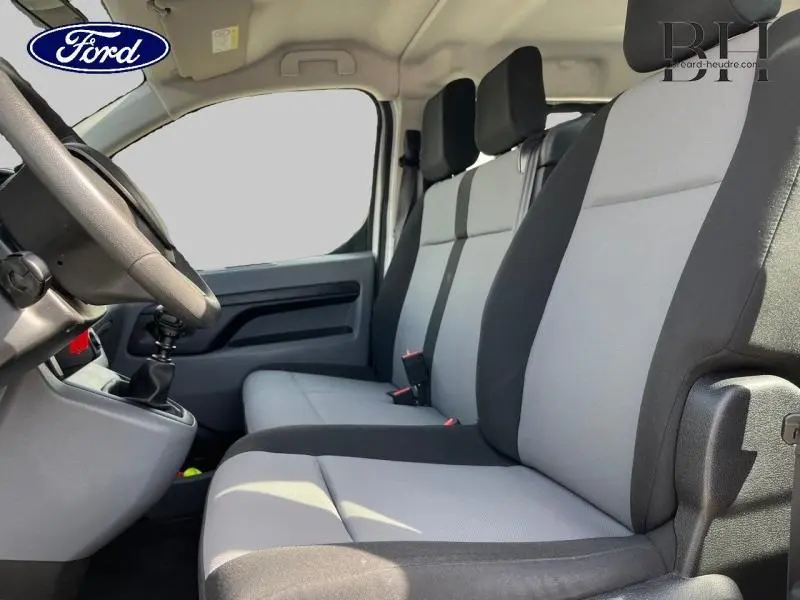 Vue intérieure côté conducteur du Peugeot Expert Fourgon 2017, sièges tissu Curitiba gris et noir, volant et levier de vitesses visibles.