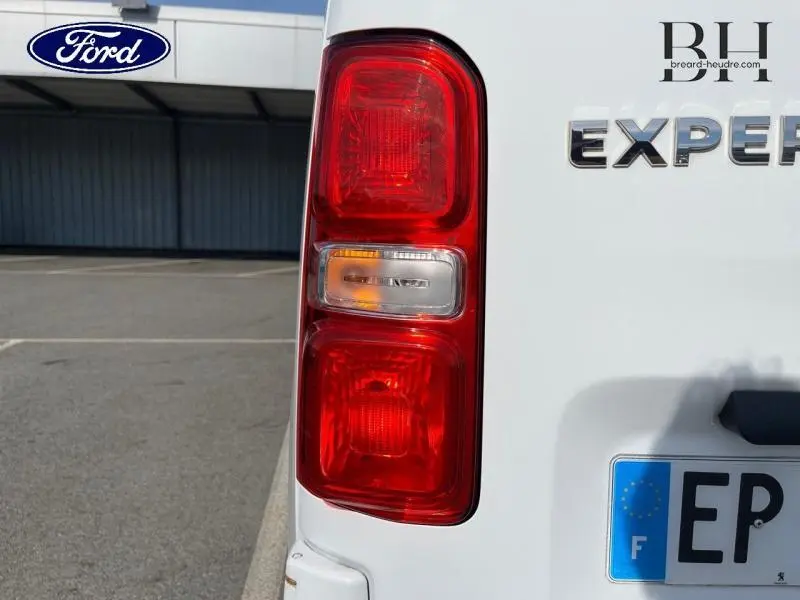 Gros plan sur le feu arrière gauche blanc banquise du Peugeot Expert Fourgon 2017 avec logo et plaque visible