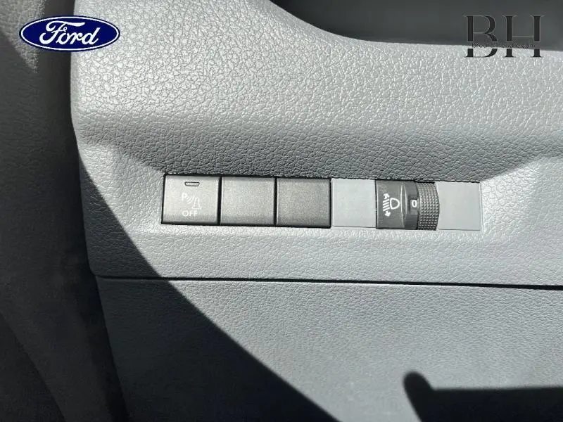 Détail des commandes de réglage des projecteurs sur tableau de bord gris du Peugeot Expert Fourgon blanc Banquise.