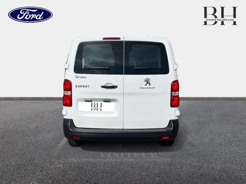 Vue arrière d'un Peugeot Expert Fourgon blanc Banquise avec portes battantes et vitres arrière teintées.