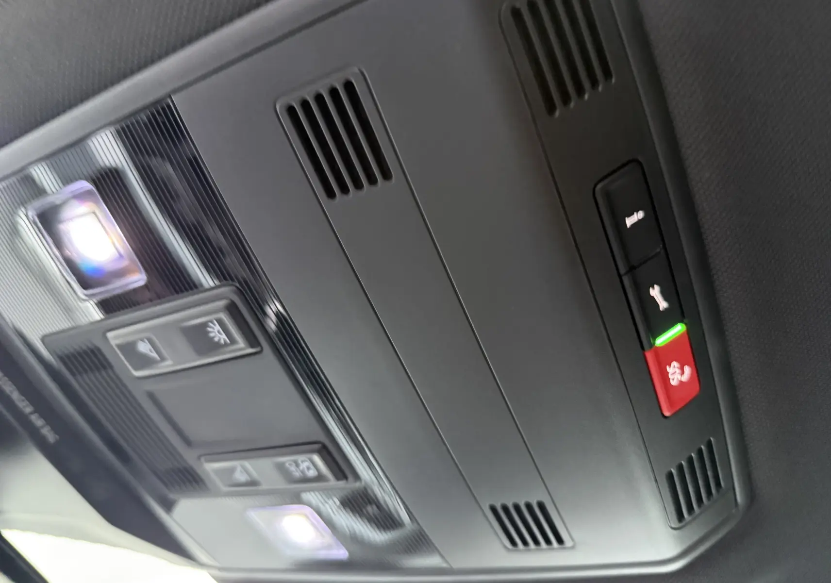 Vue intérieure du plafonnier noir du Volkswagen T-Roc 2025, avec éclairages LED et boutons de commande intégrés.