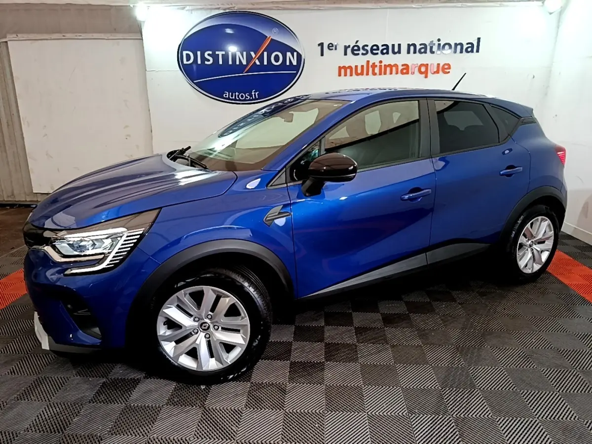 Renault Captur bleu 2023 en vue de profil côté gauche, avec jantes argentées et rétroviseurs noirs.