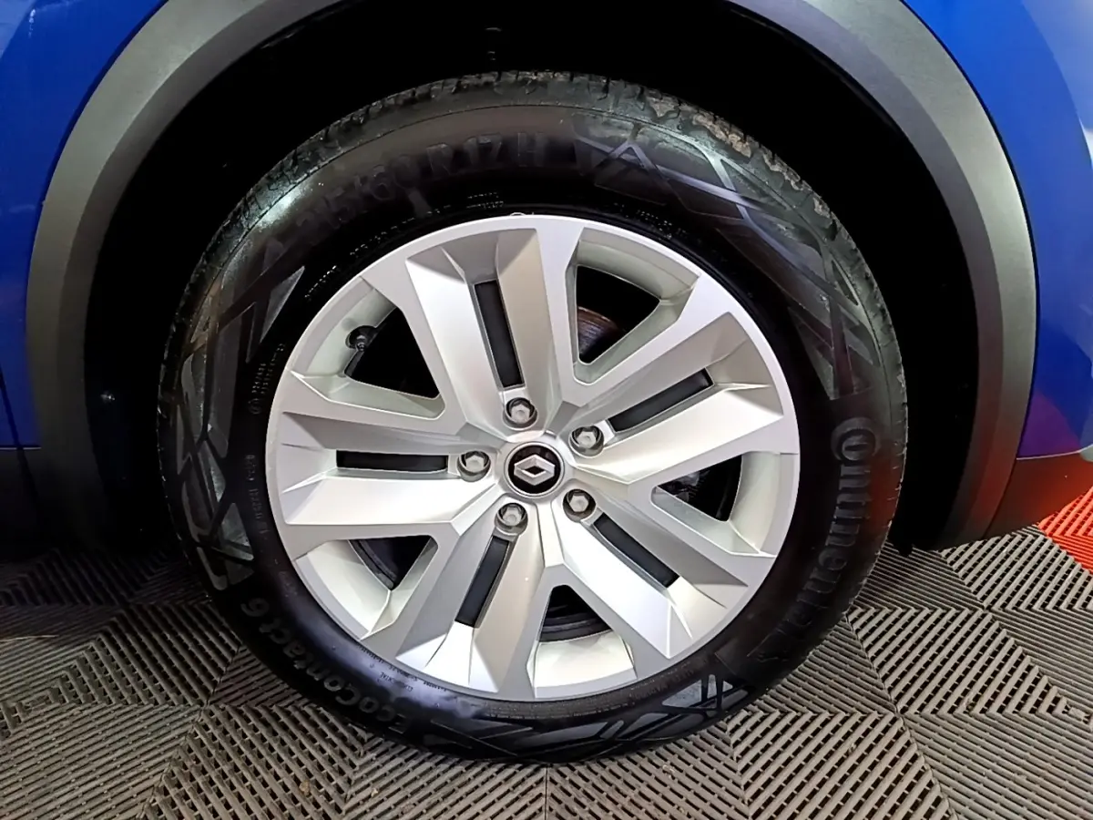 Gros plan sur la roue avant droite du Renault Captur bleu, mettant en valeur la jante alliage et le pneu Continental.