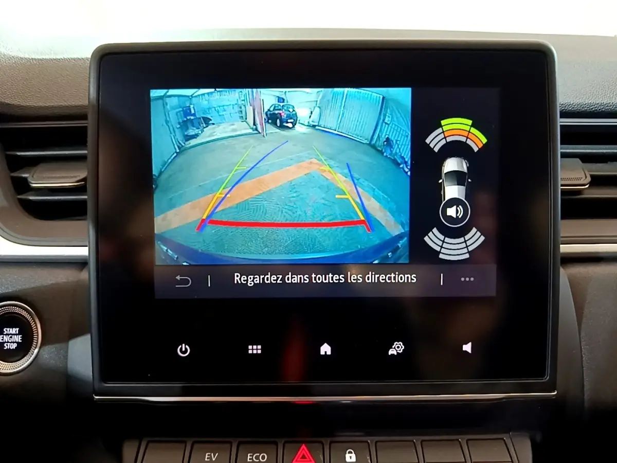 Écran tactile intérieur affichant la caméra de recul et l’aide au stationnement du Renault Captur bleu, vue du tableau de bord.
