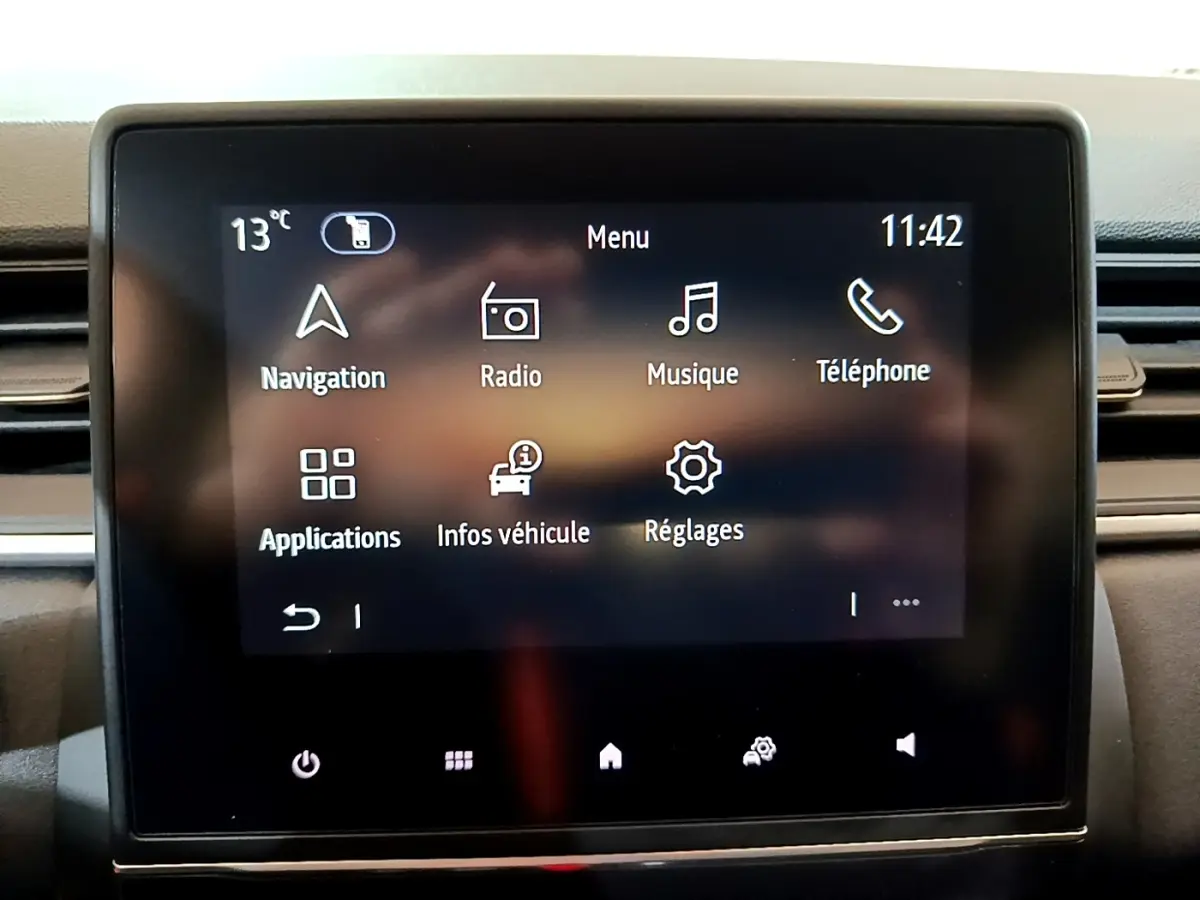 Écran tactile central du tableau de bord du Renault Captur bleu, affichant le menu principal avec navigation et réglages.