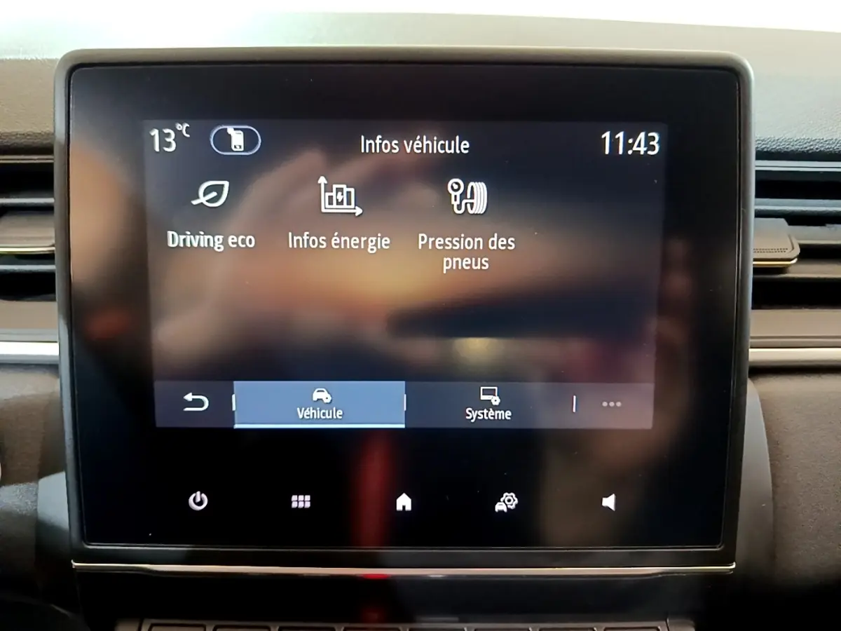 Écran tactile central du tableau de bord du Renault Captur 2023 affichant les infos véhicule en mode hybride.