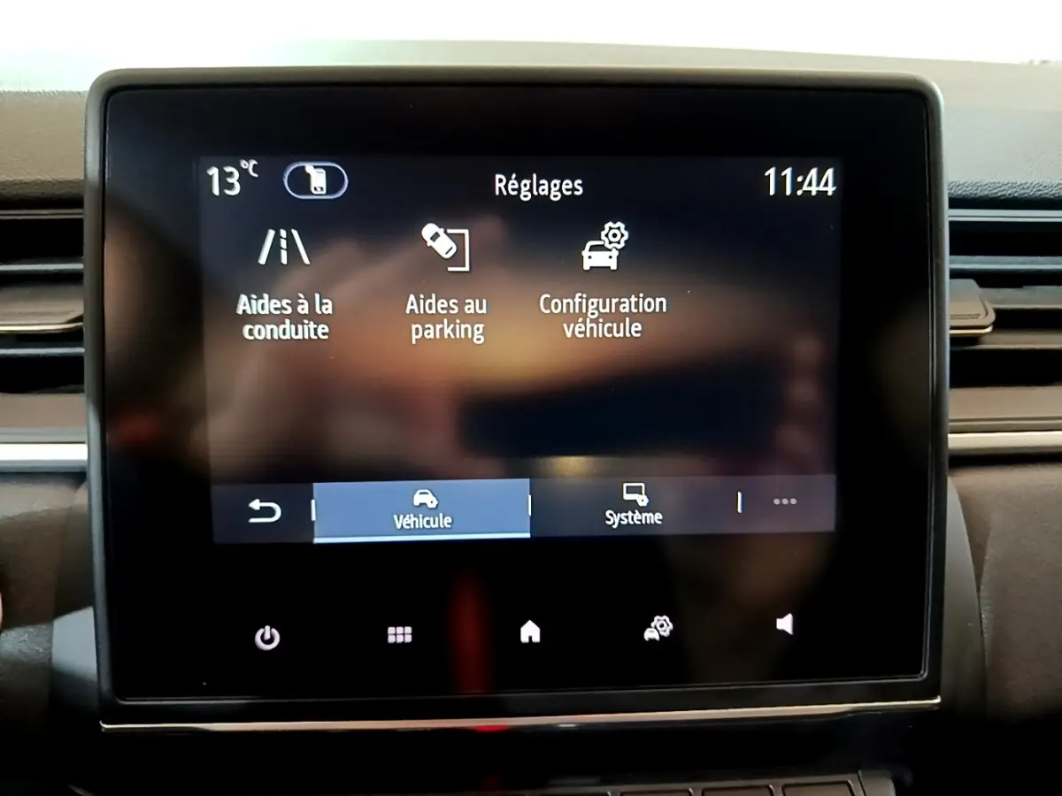 Écran tactile central du tableau de bord du Renault Captur bleu, affichant le menu réglages véhicule.