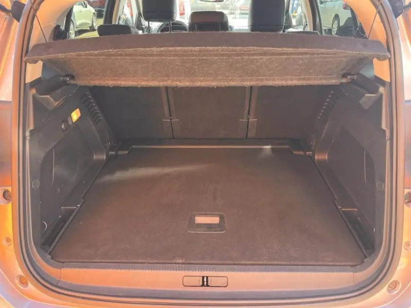 Vue arrière du coffre ouvert d'un Citroën C5 Aircross gris, montrant l'espace de chargement et la tablette cache-bagages relevée.