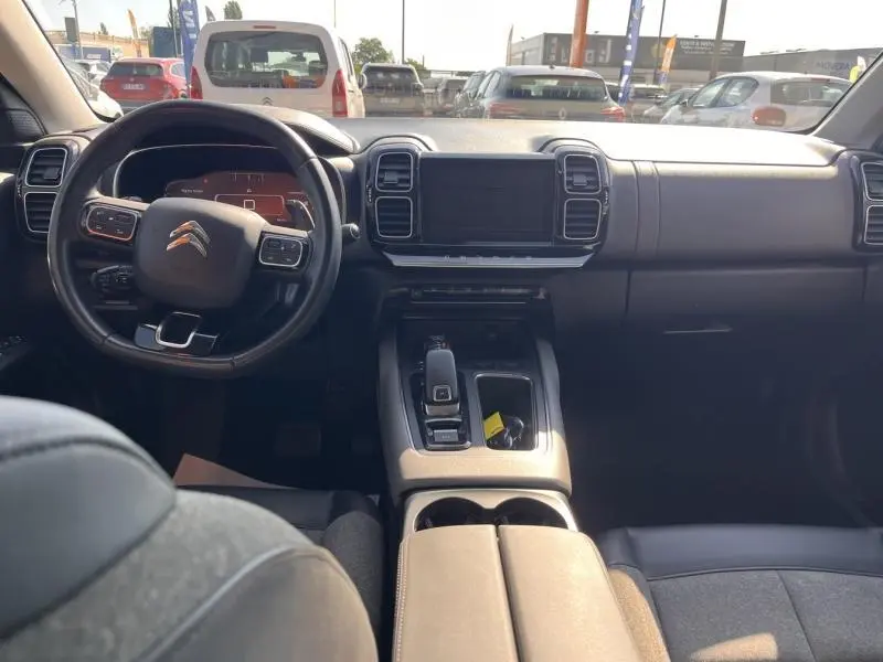 Vue intérieure avant du Citroën C5 Aircross gris, montrant le volant cuir multifonction et l’écran tactile central.