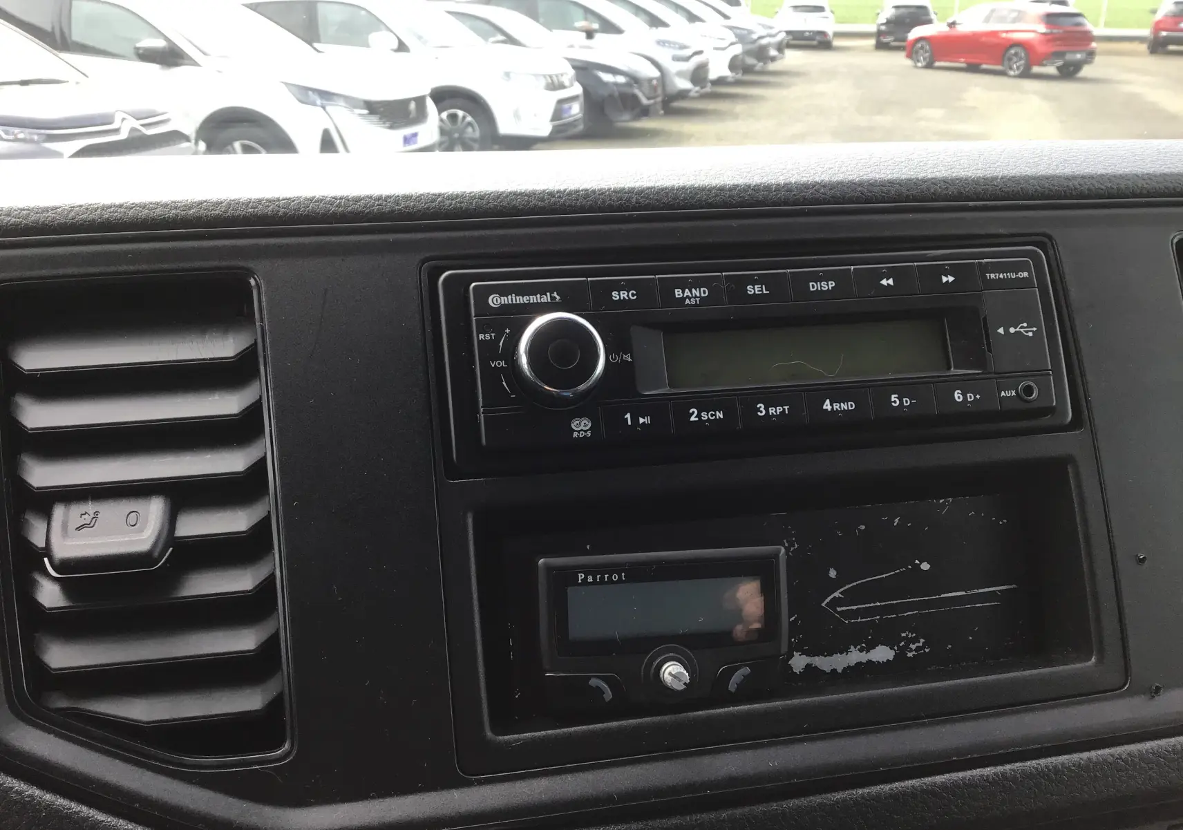 Tableau de bord noir du Volkswagen Crafter 2017 avec autoradio Continental et commande d'aération visible en gros plan.