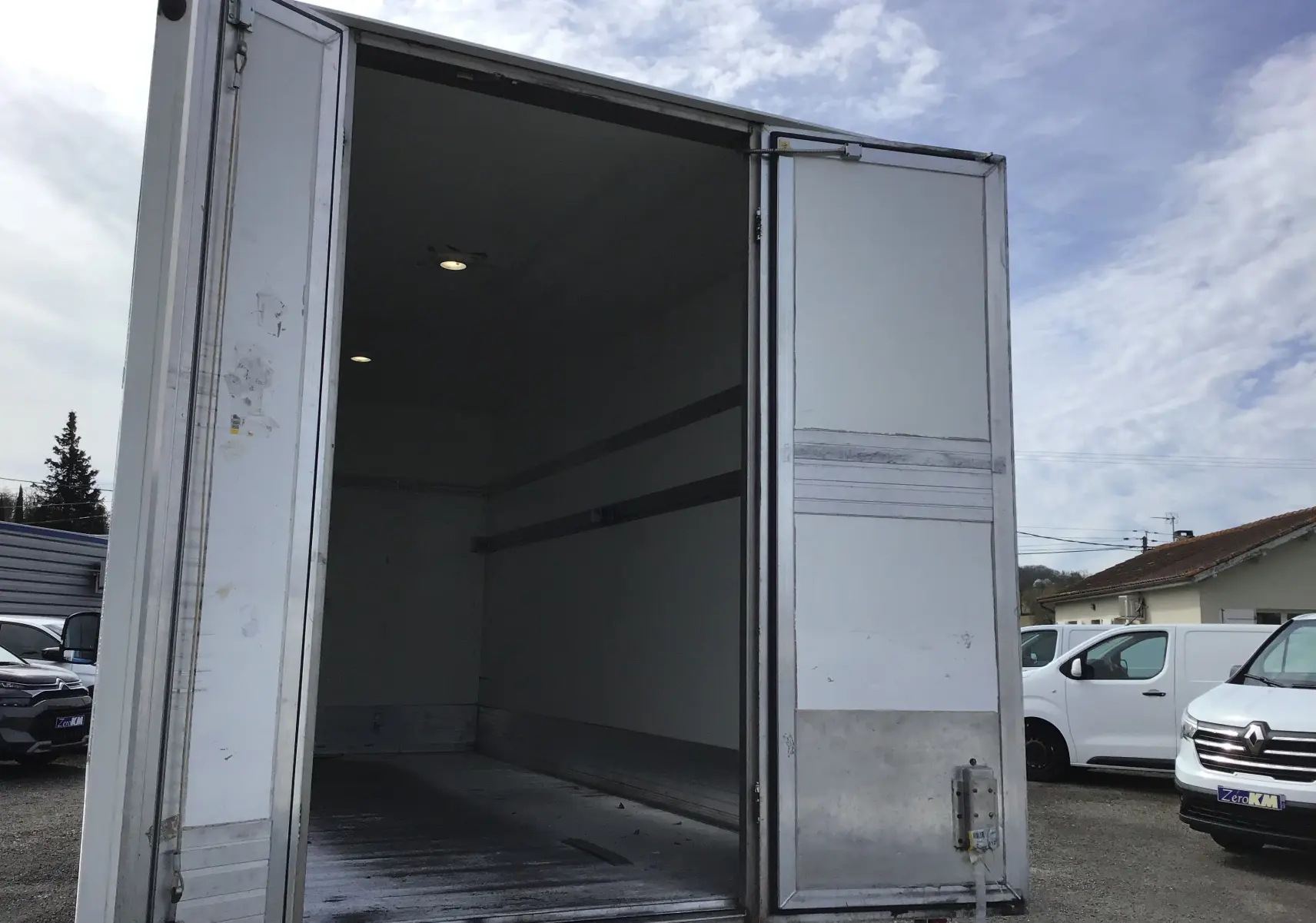 Vue arrière du Volkswagen Crafter Châssis Cabine bleu 2017 avec porte arrière ouverte montrant la caisse vide en aluminium.