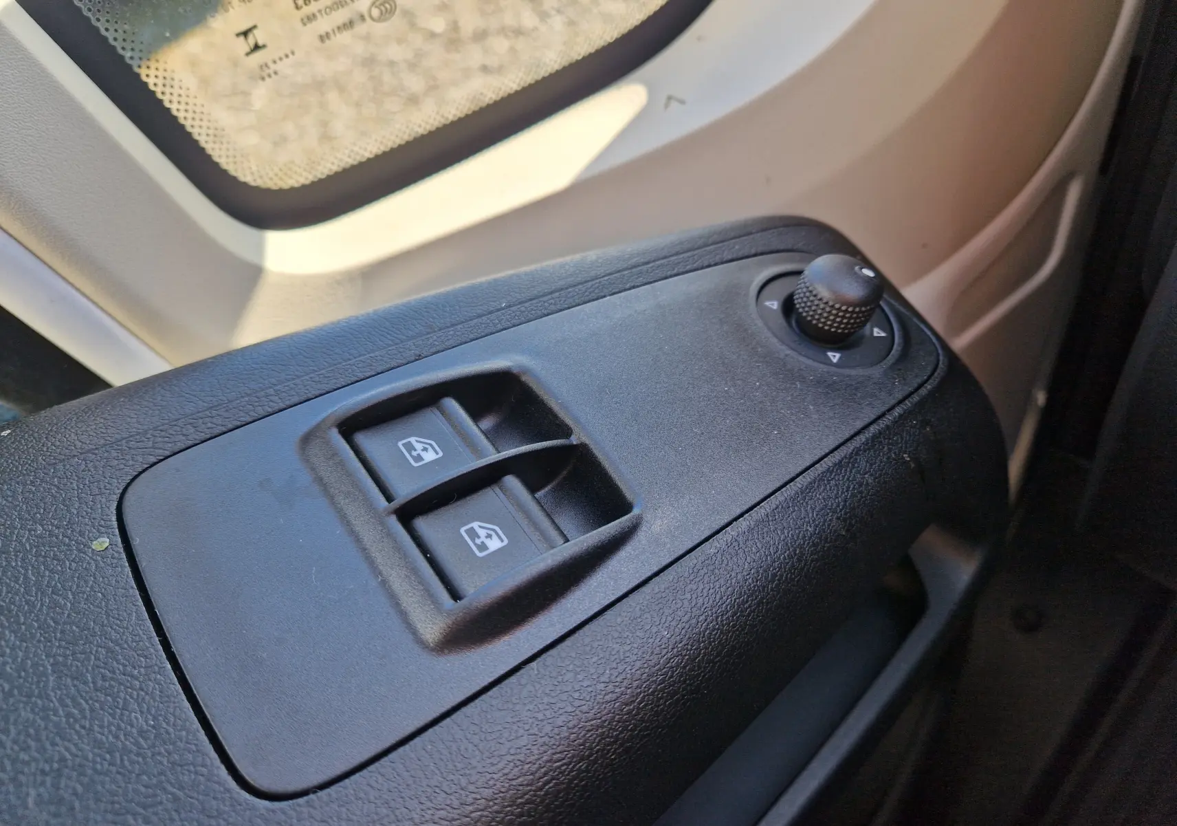 Gros plan sur les commandes de lève-vitres et réglage des rétroviseurs côté conducteur du Fiat Ducato blanc 2023.