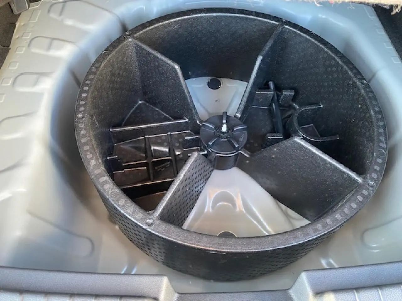 Rangement compartimenté en plastique noir dans le coffre du Dacia Duster 2025 beige Sandstone, version essence.