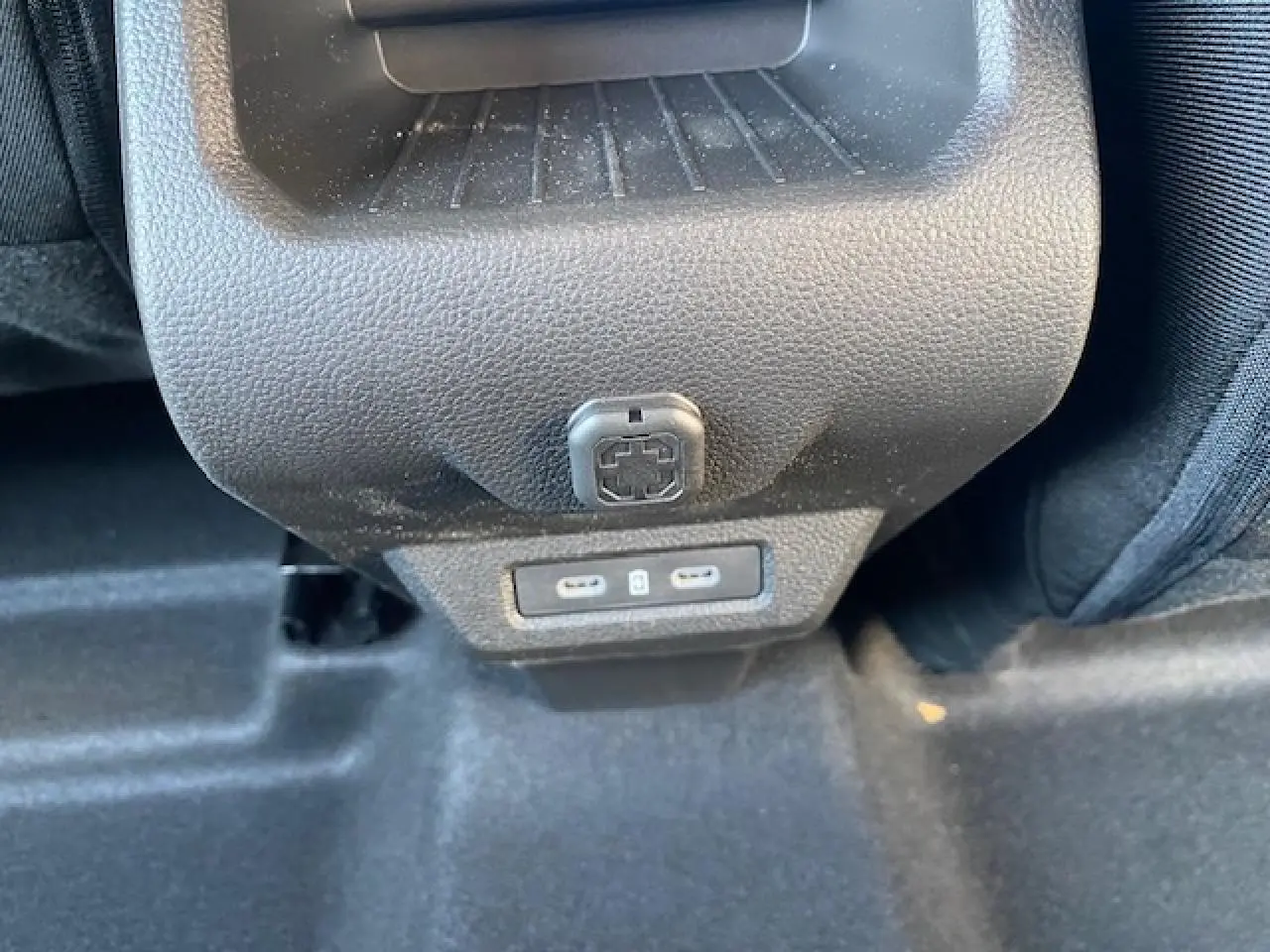 Prise USB double et prise 12V en gros plan au dos de la console centrale du Dacia Duster 2025.