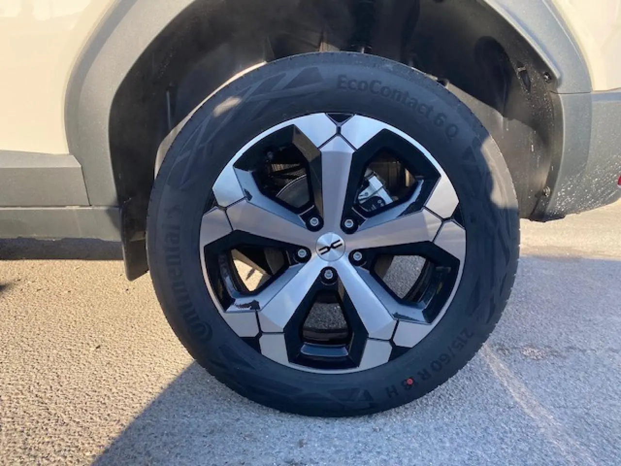 Gros plan sur la roue avant gauche du Dacia Duster beige Sandstone 2025, avec jante alliage noire et argentée.
