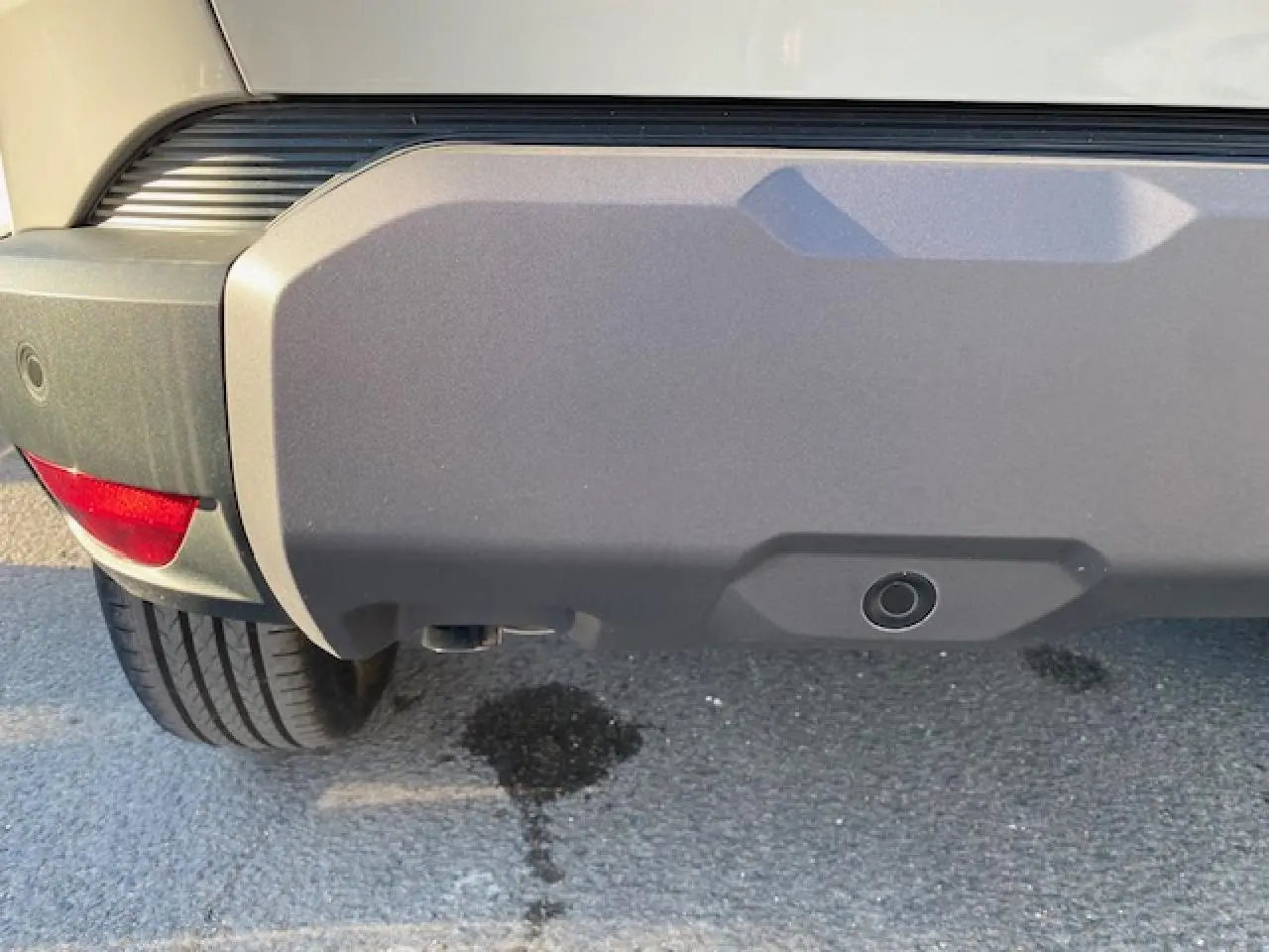 Gros plan sur le pare-chocs arrière beige sandstone du Dacia Duster 2025, avec capteur de recul visible.