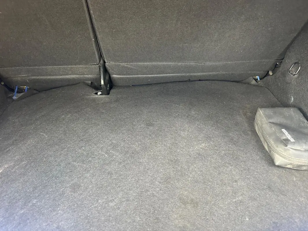 Coffre spacieux de Dacia Sandero Stepway bleu foncé, vue intérieure arrière avec siège rabattable et trousse noire.