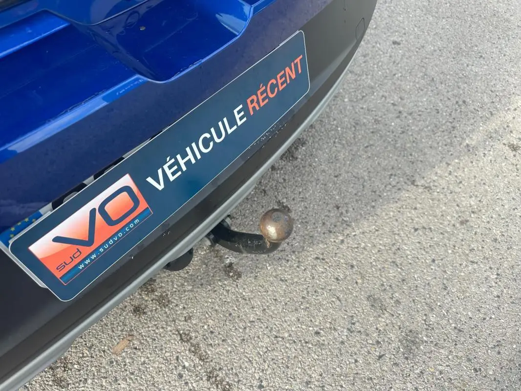 Gros plan sur l'attelage arrière d'une Dacia Sandero Stepway bleu foncé avec plaque "Véhicule récent" visible.