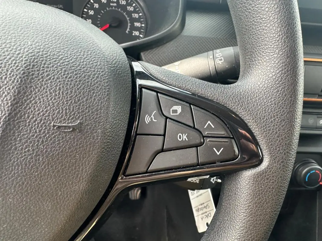 Gros plan sur le volant noir de la Dacia Sandero Stepway 2021, mettant en valeur les commandes multifonctions à droite.