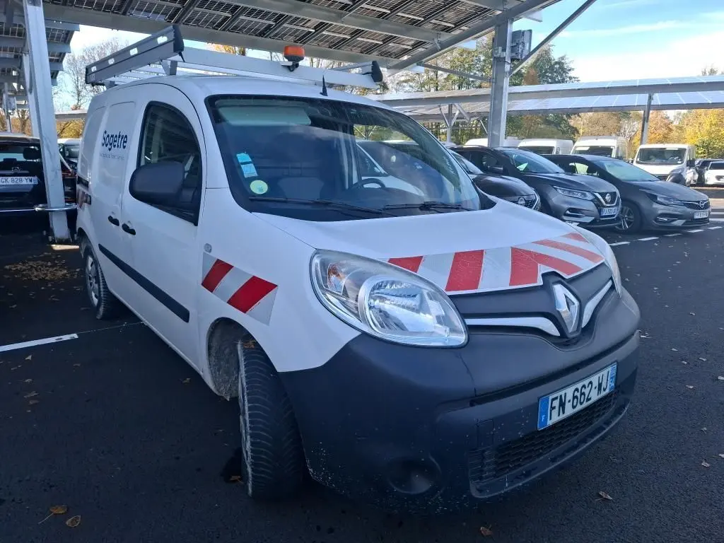 Vue 3/4 avant d’un Renault Kangoo blanc 2020 avec bandes rouges réfléchissantes sur capot et ailes, stationné sur gravier.