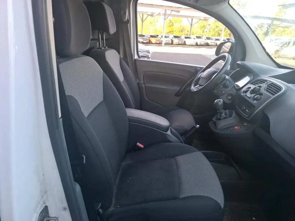 Vue arrière ouverte du Renault Kangoo blanc 2020, montrant l'aménagement intérieur en bois avec étagères et rangements.