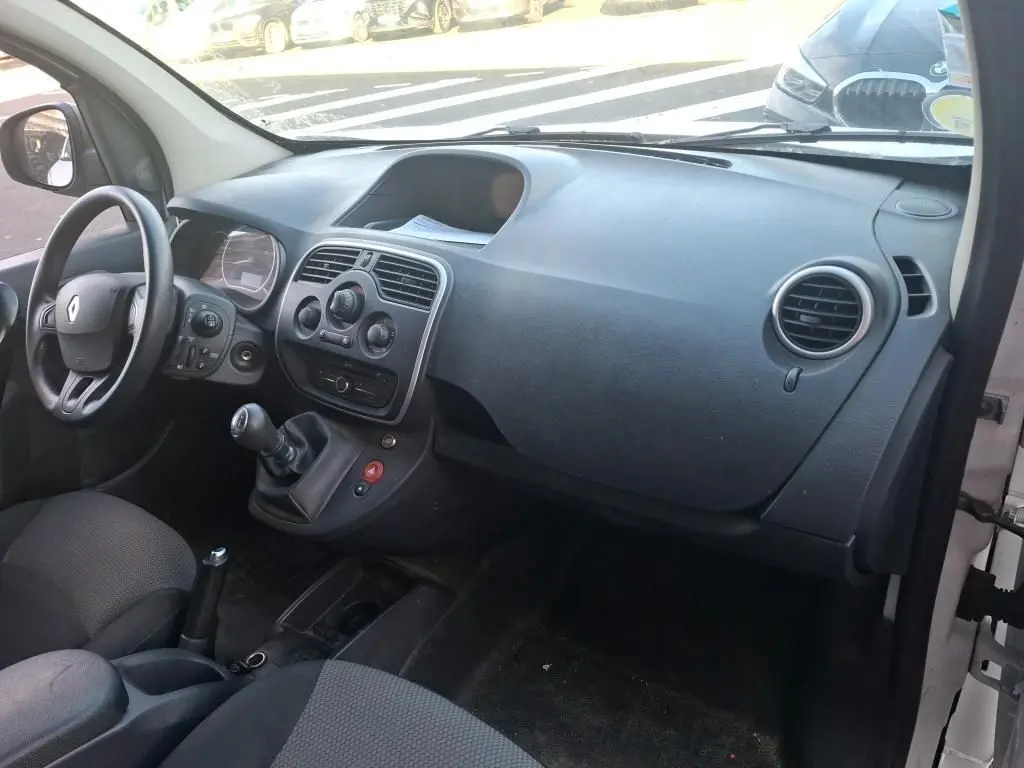 Vue de profil droit d’un Renault Kangoo blanc 2020 avec porte latérale coulissante ouverte montrant l’aménagement intérieur en bois.