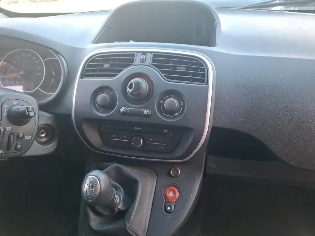 Vue intérieure arrière du Renault Kangoo blanc 2020, montrant les étagères en bois intégrées au compartiment de chargement.