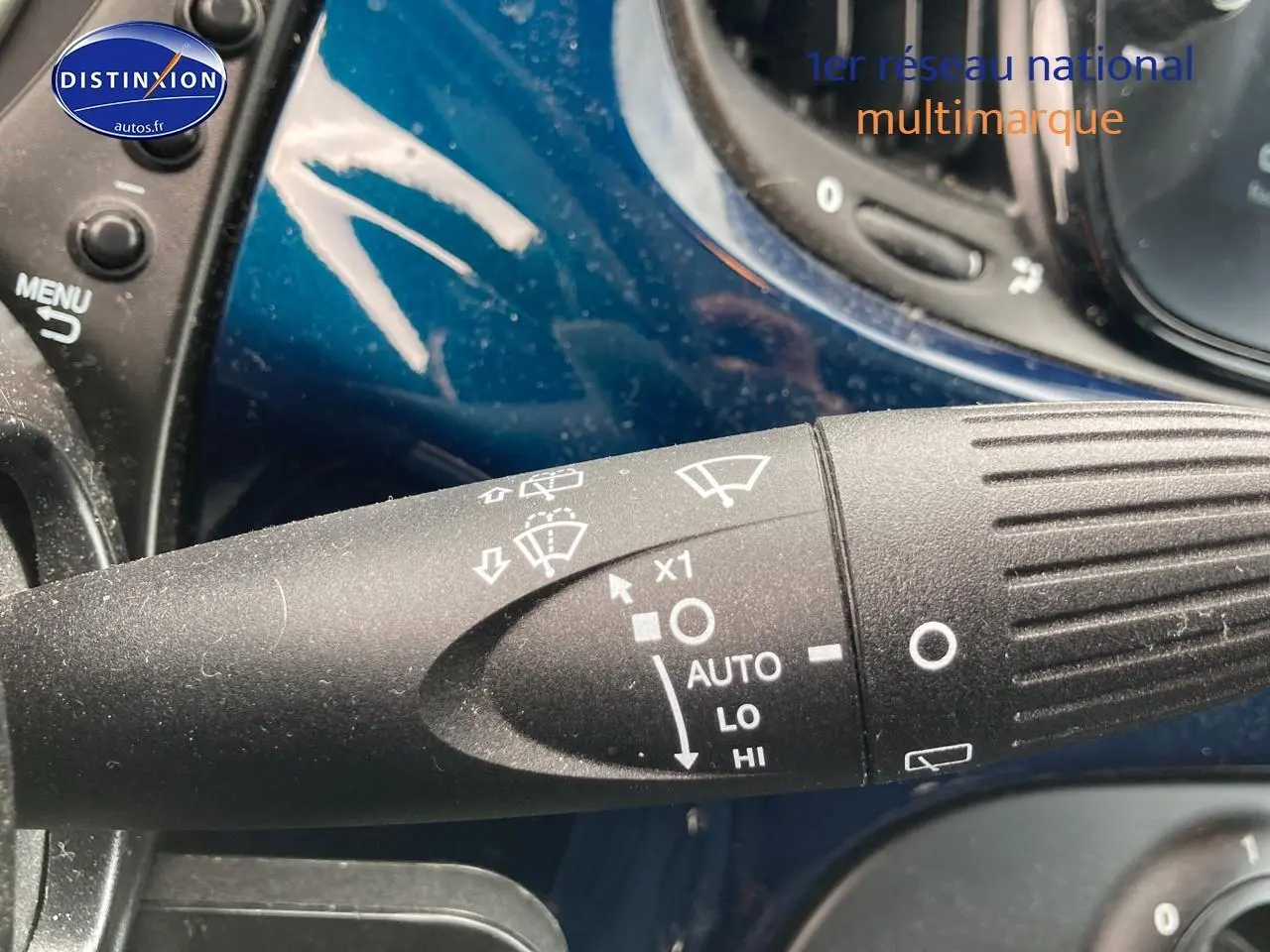 Gros plan sur la commande d’essuie-glace avec fond bleu brillant du tableau de bord d’une FIAT 500 2023.