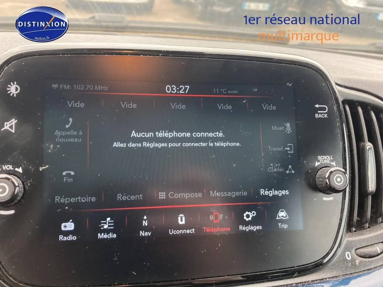 Gros plan sur l'écran tactile central du tableau de bord d'une FIAT 500 bleu, affichant le menu téléphone non connecté.