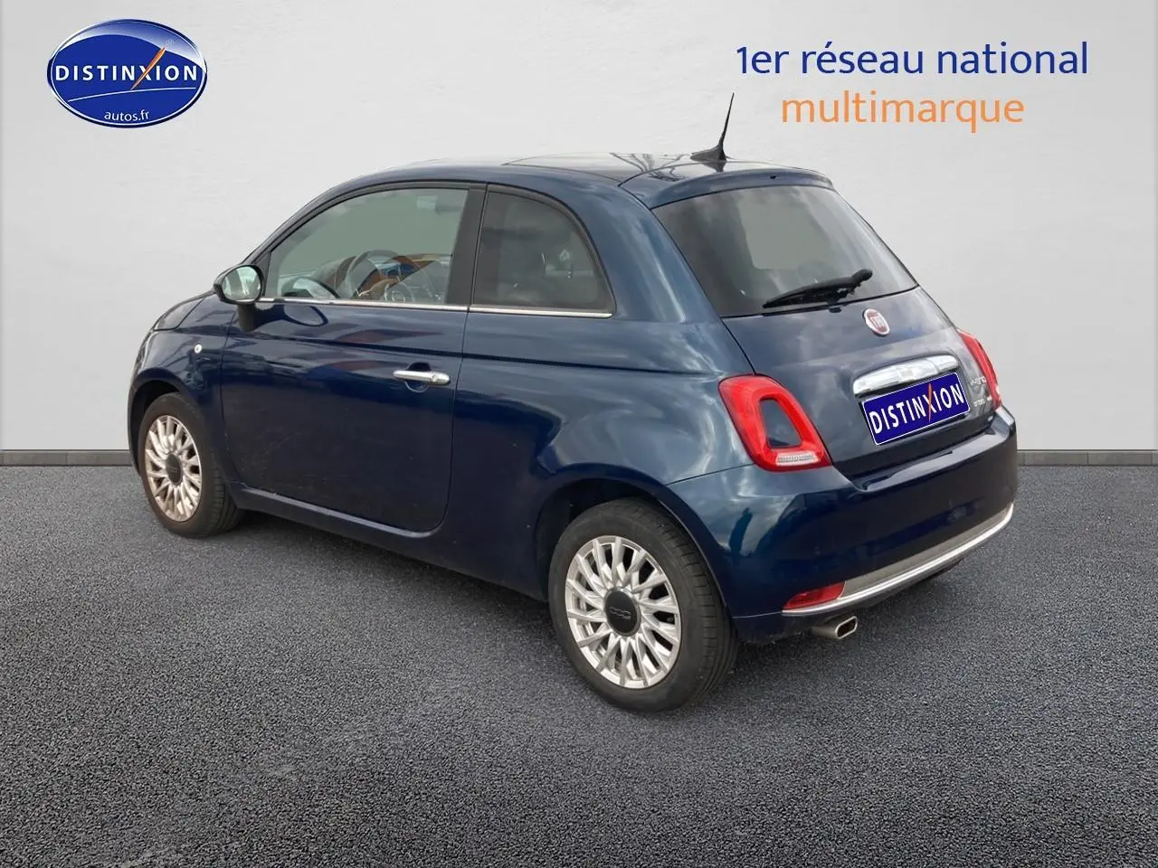 Vue 3/4 arrière droite d'une FIAT 500 bleu foncé 2023 avec jantes alu et feux arrière LED.