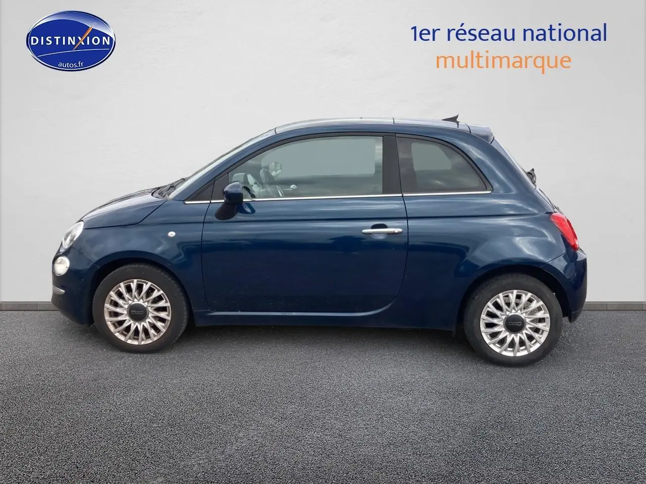 Profil latéral gauche d'une FIAT 500 bleu foncé 2023 avec jantes alu et toit panoramique en verre.
