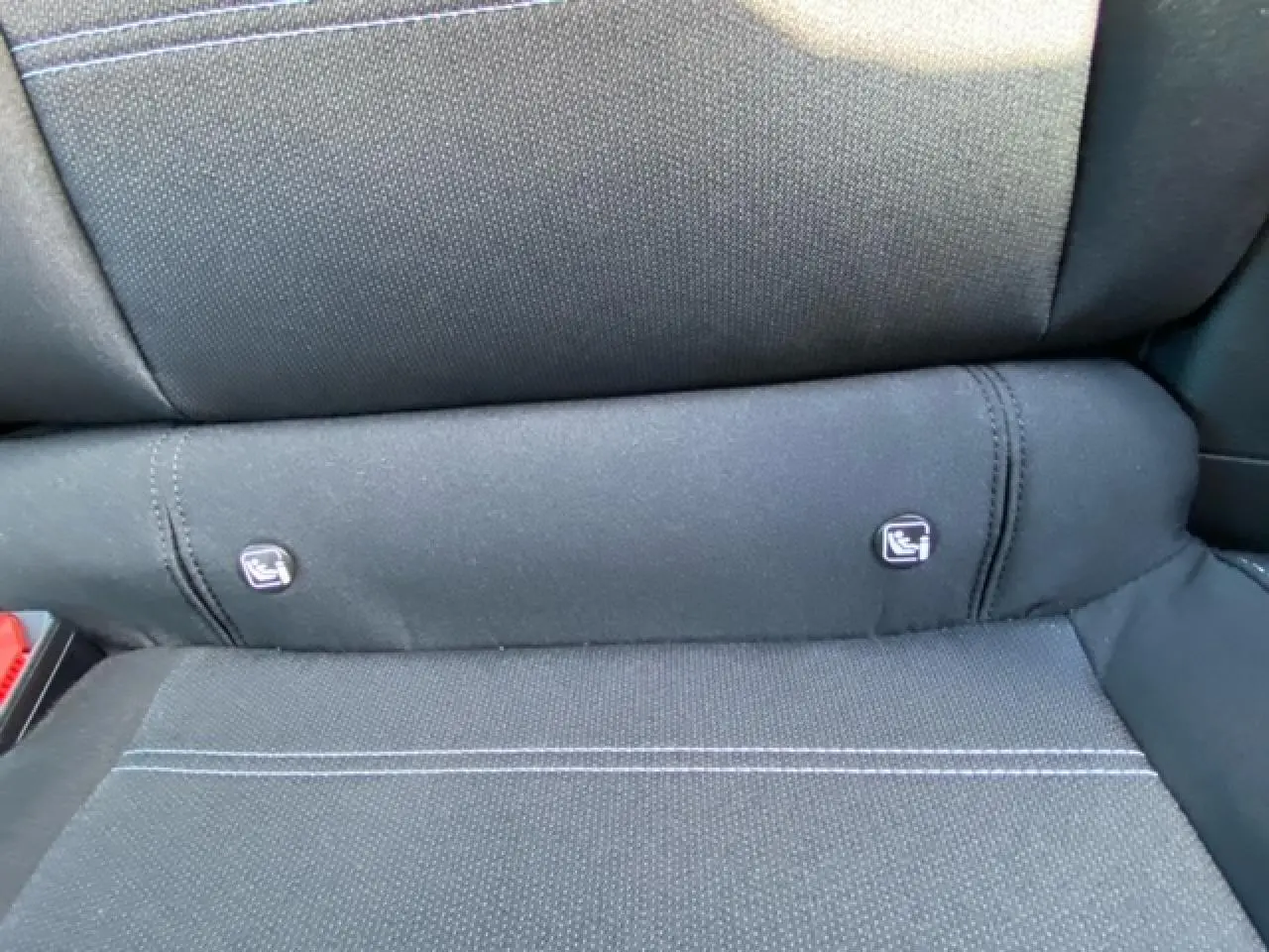 Détail des fixations Isofix sur la banquette arrière en tissu noir de la Dacia Logan 2022 gris.