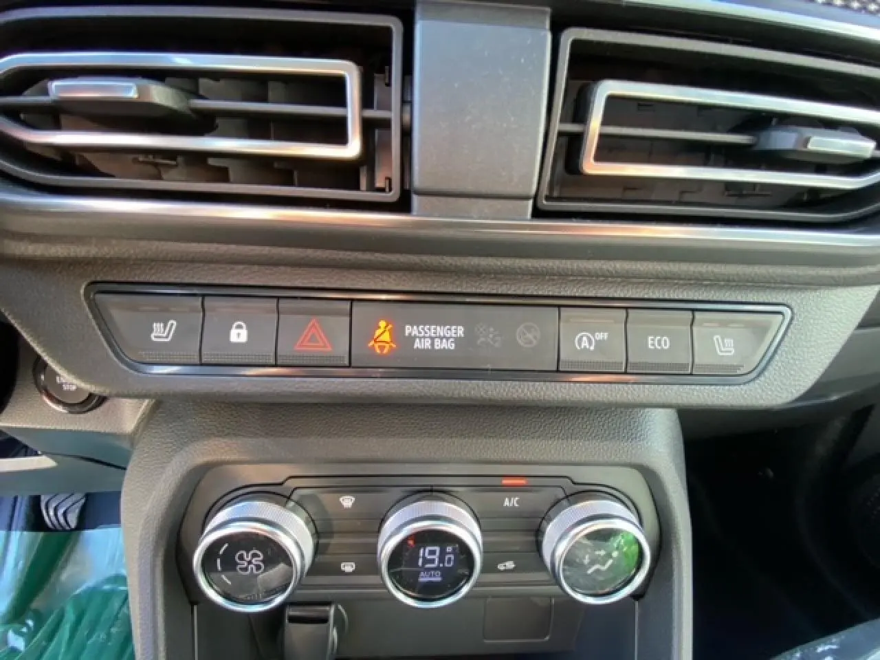 Détail du tableau de bord de la Dacia Logan 2022, montrant les commandes de climatisation automatique et les boutons de sécurité.
