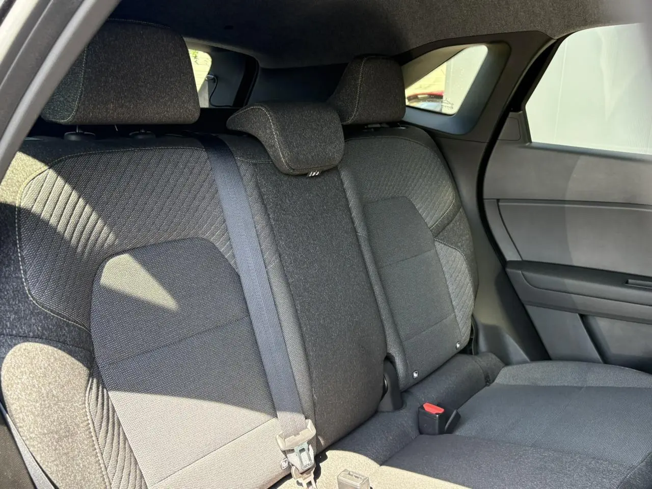 Vue intérieure du siège arrière droit de la Renault SYMBIOZ E-Tech Full Hybrid 2025 en tissu gris foncé.