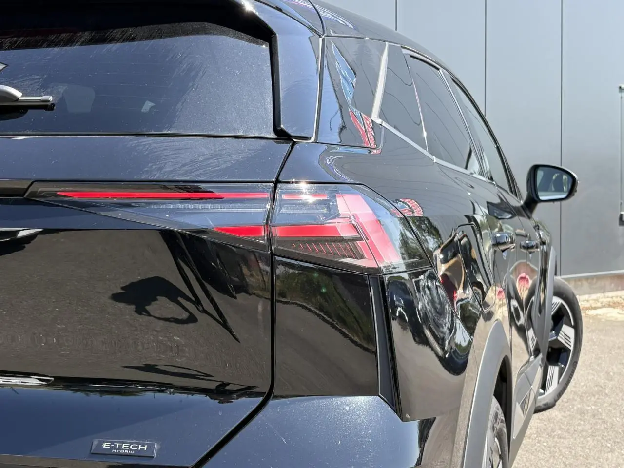 Vue 3/4 arrière droite du Renault SYMBIOZ noir étoilé avec feux arrière LED et jantes 18 pouces visibles.