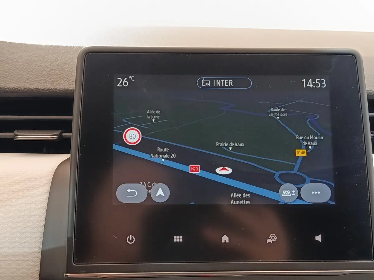 Écran tactile central de navigation 3D affichant une carte routière dans une Renault Clio blanche, vue intérieure.