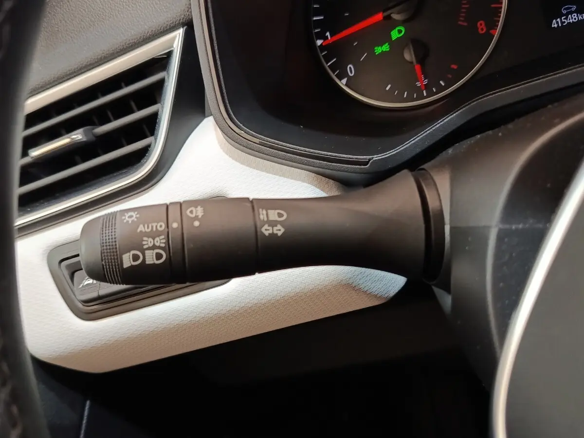 Gros plan sur la commande des phares et clignotants côté gauche du tableau de bord blanc de la Renault Clio Evolution TCe 90.