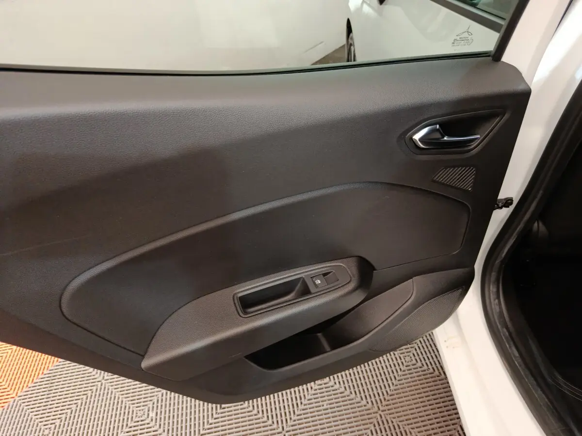 Vue intérieure de la porte arrière droite noire d'une Renault Clio Evolution TCe 90 blanche 2023, avec commande de vitre.