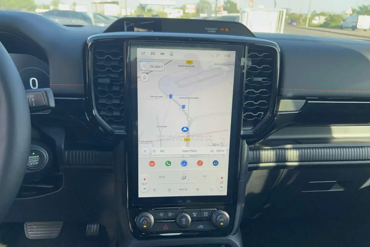 Vue intérieure centrée sur l’écran tactile vertical du Ford Ranger Wildtrak 2026 avec tableau de bord noir et volant partiel.