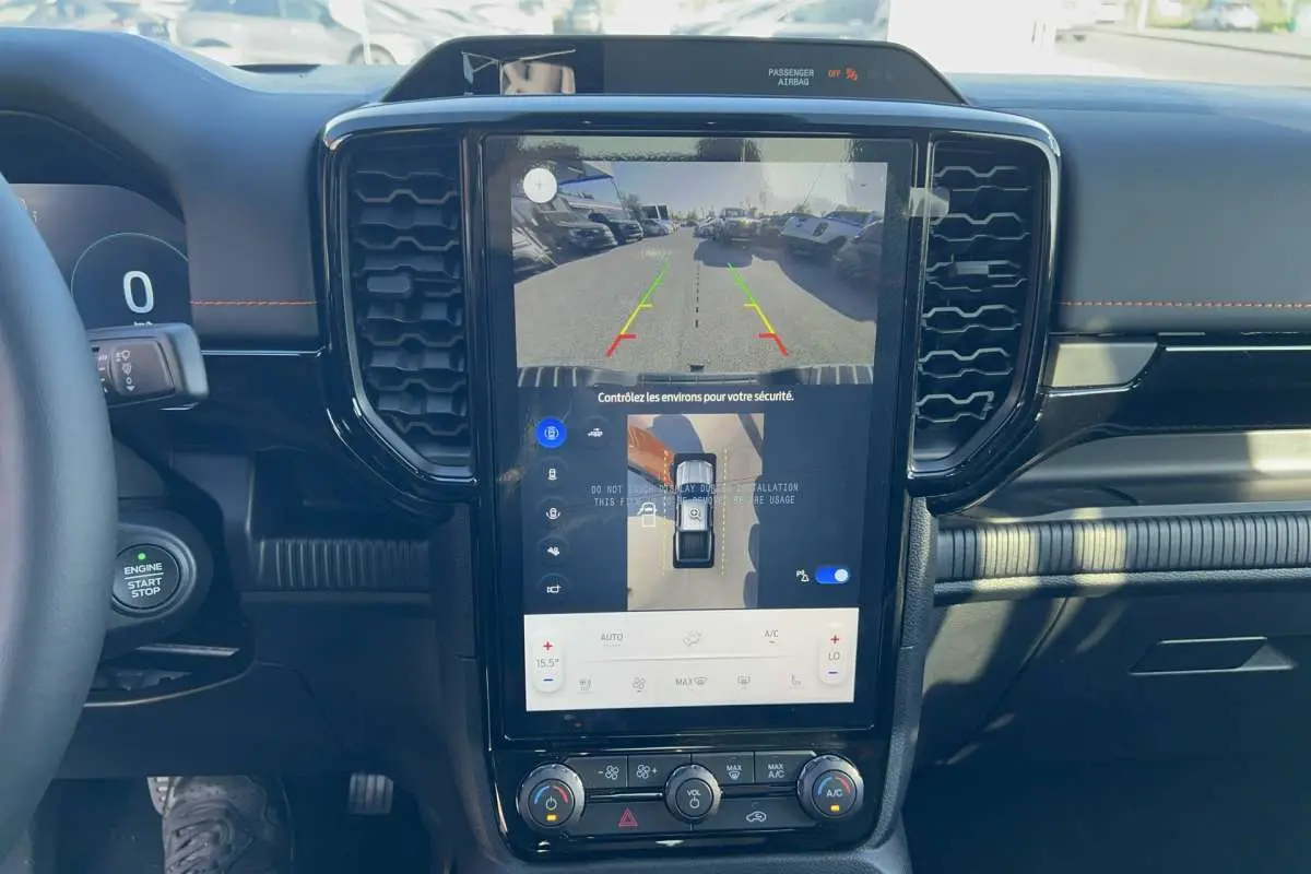 Vue intérieure centrée sur l'écran tactile vertical du Ford Ranger Wildtrak 2026 avec affichage caméra 360° et tableau de bord noir.