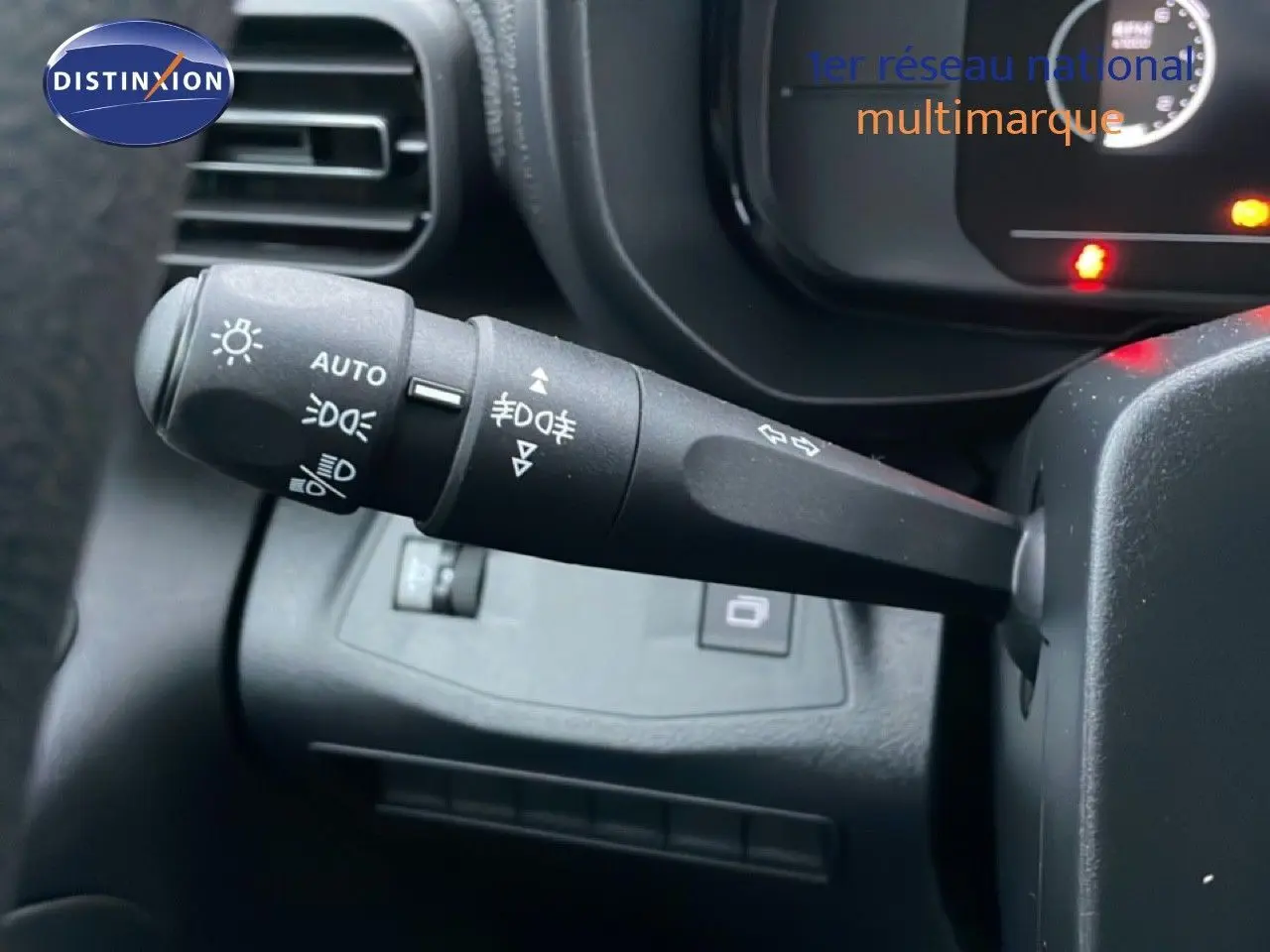 Gros plan sur la manette de commande des feux à gauche du volant dans un Citroën Berlingo Van XL noir Perla Metal 2025.