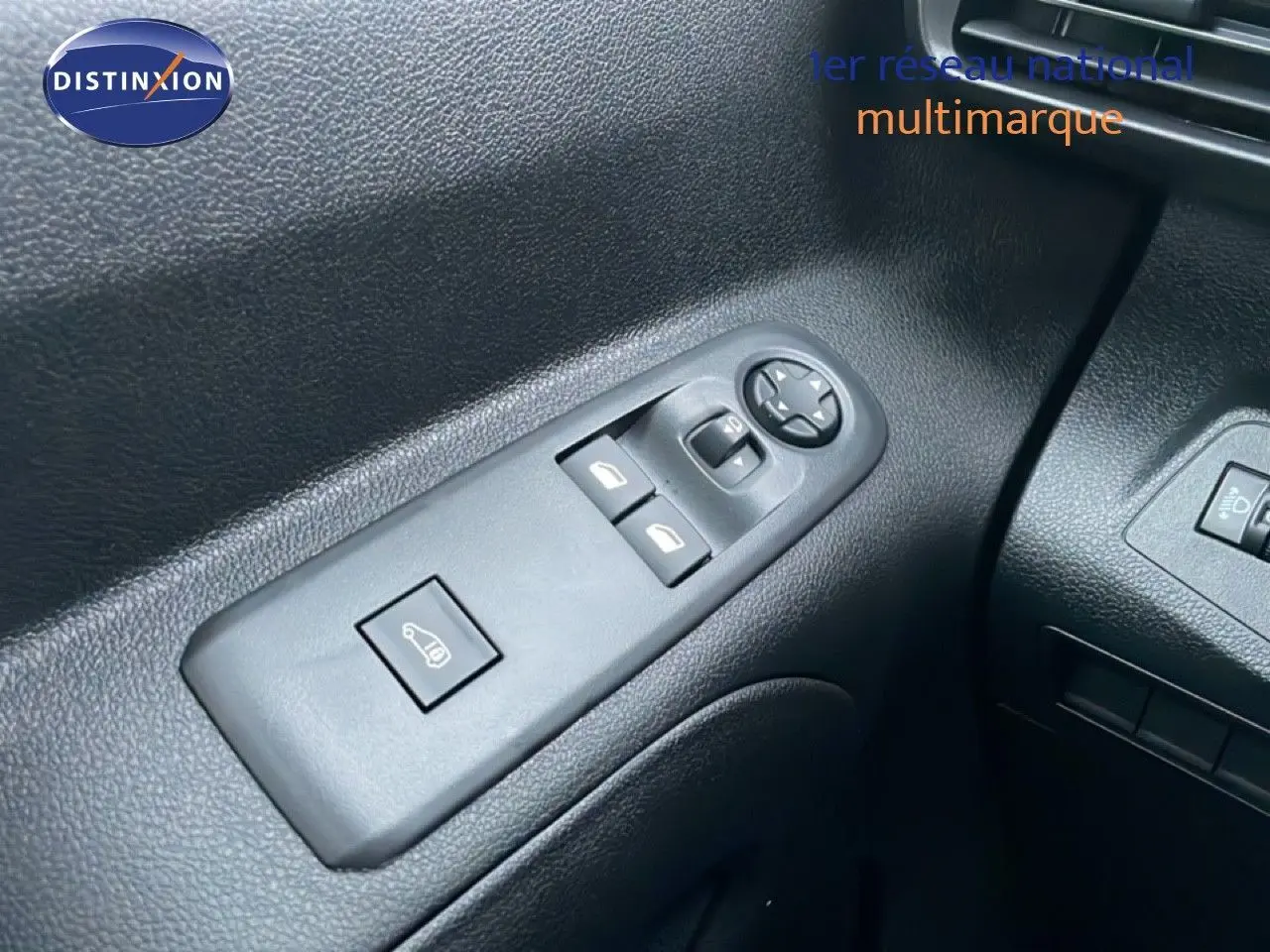 Gros plan sur les commandes de lève-vitres et réglage des rétroviseurs côté conducteur du Citroën Berlingo noir Perla Metal 2025.