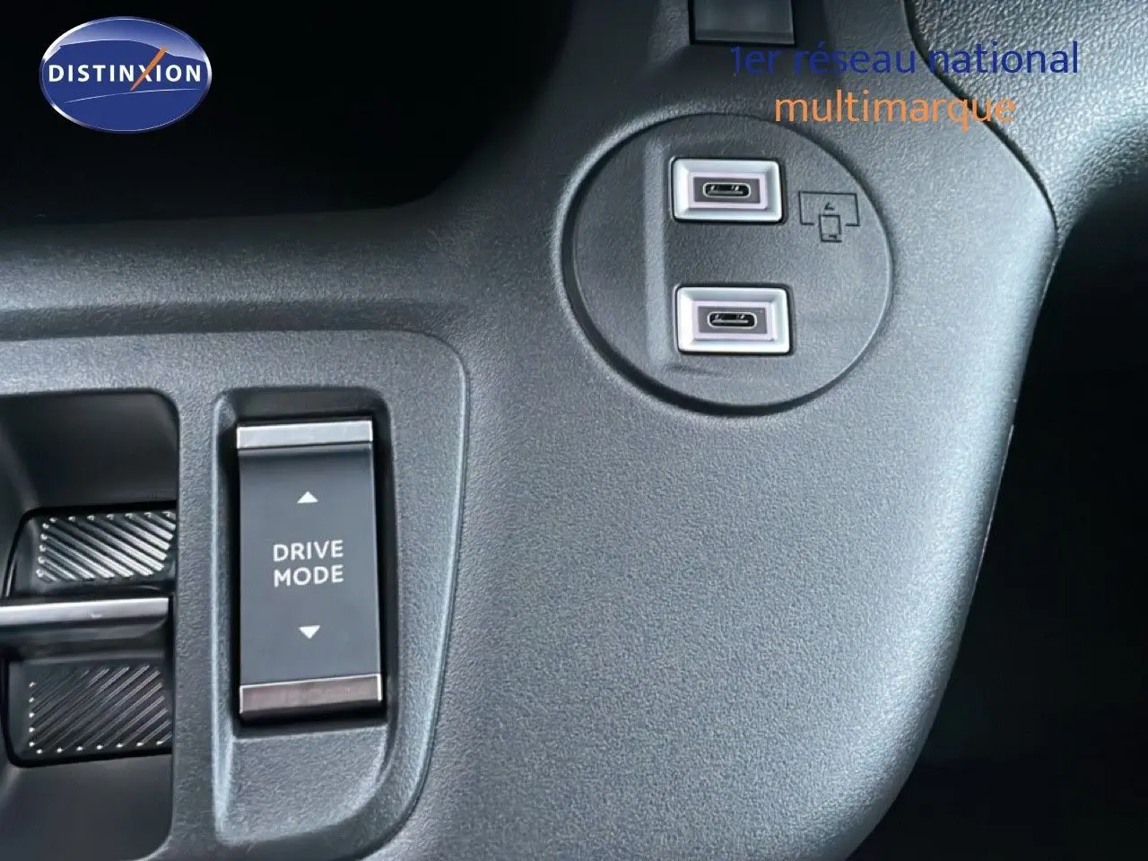 Gros plan sur la console centrale noire du Citroën Berlingo 2025, montrant les ports USB-C et le bouton Drive Mode.