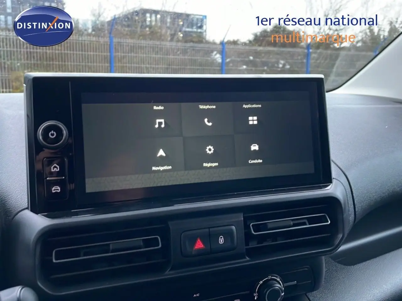 Écran tactile central du tableau de bord du Citroën Berlingo 2025, avec commandes de navigation et climatisation visibles.