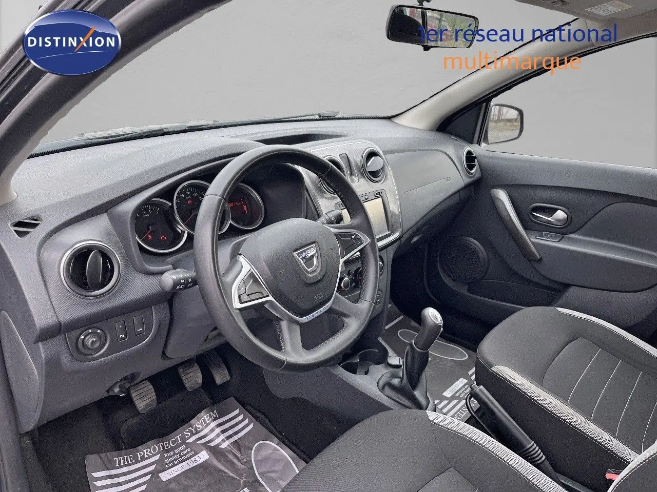 Intérieur de la Dacia Sandero Stepway 2016 en gris foncé, vue côté conducteur montrant le tableau de bord et volant.