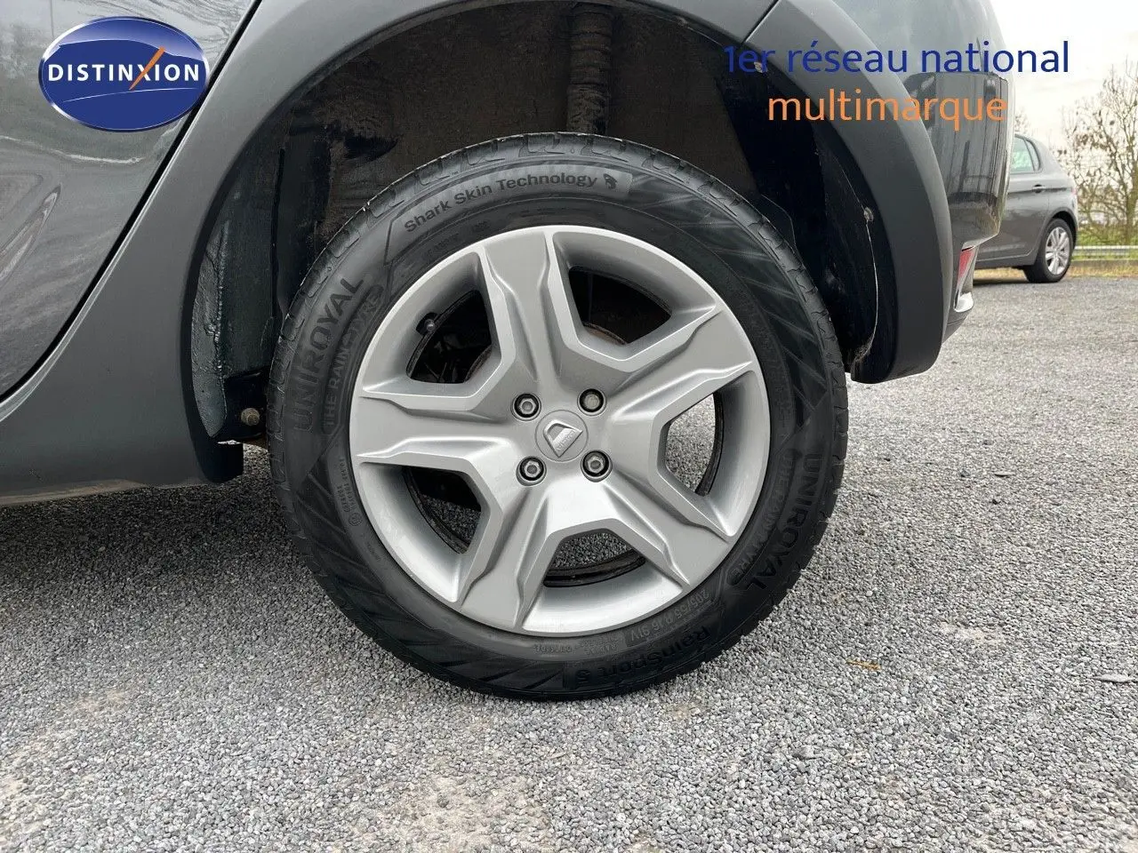 Gros plan sur la roue avant droite d'une Dacia Sandero Stepway gris foncé, avec jante alliage et pneu Uniroyal.