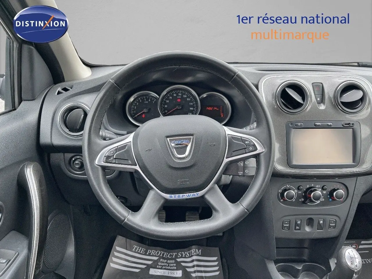 Vue intérieure frontale du volant et tableau de bord gris foncé de la Dacia Sandero Stepway 2016 essence.