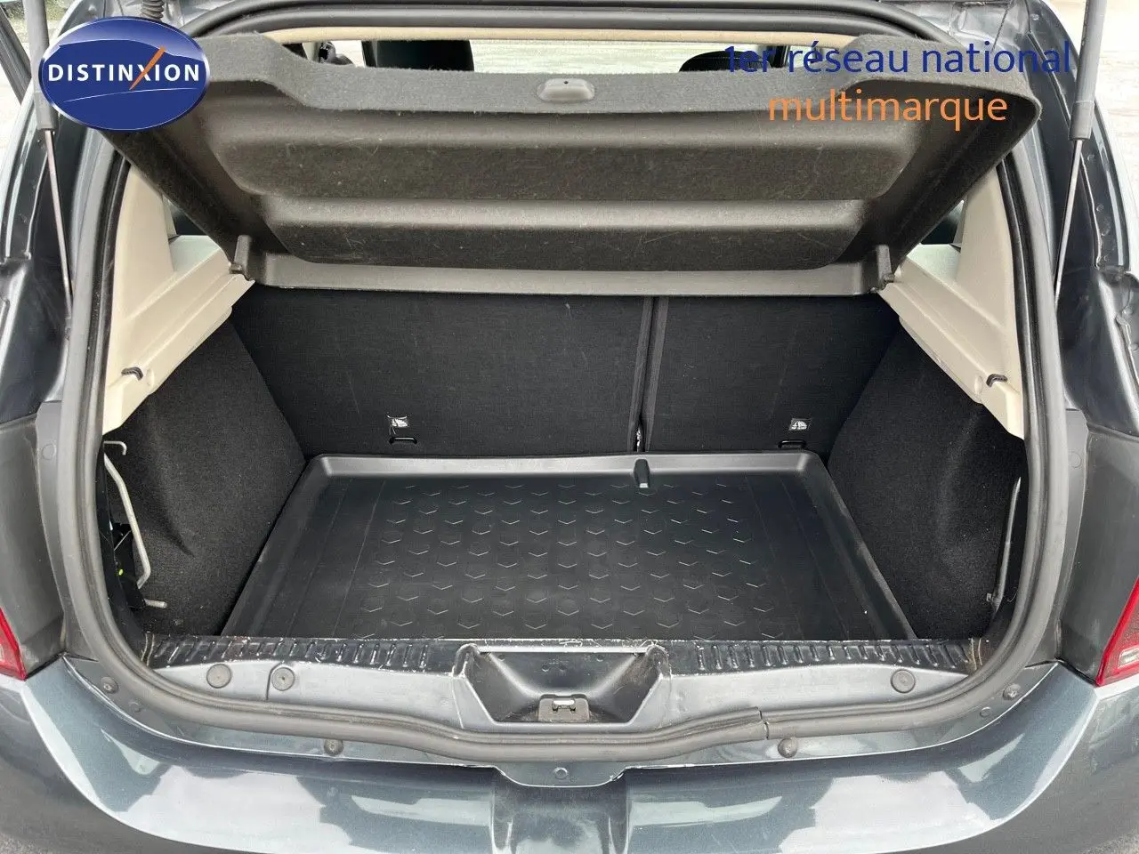 Coffre ouvert vu de l'arrière d'une Dacia Sandero Stepway gris foncé, montrant l'espace de chargement vide.