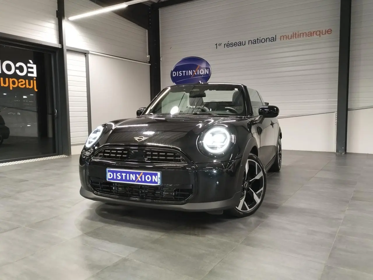 MINI Cabriolet noir vue 3/4 avant droit, phares LED allumés, jantes 16 pouces design 4-Square Spoke.